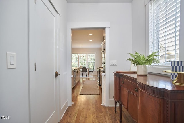 hall featuring recessed lighting, baseboards, and wood finished floors