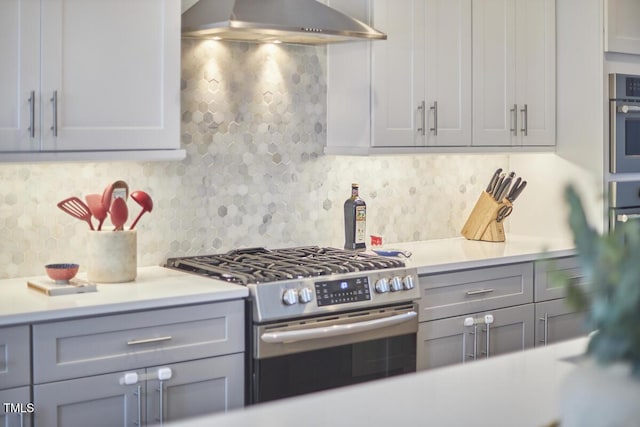 kitchen featuring light countertops, appliances with stainless steel finishes, gray cabinets, and under cabinet range hood