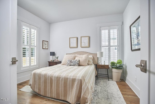 bedroom featuring wood finished floors and baseboards