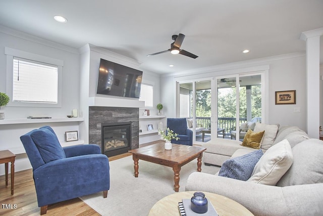 living room featuring recessed lighting, ornamental molding, wood finished floors, and a high end fireplace