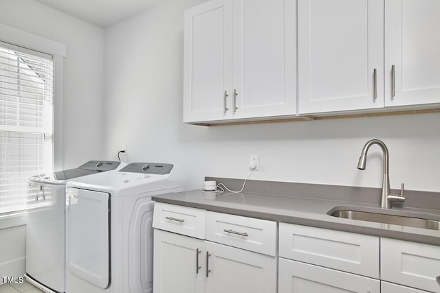 laundry room featuring cabinet space, a sink, and washer and clothes dryer