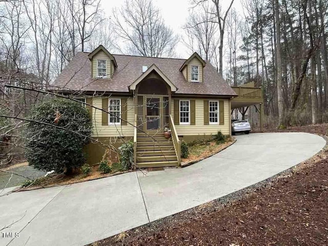 cape cod home featuring crawl space, an attached carport, concrete driveway, and roof with shingles