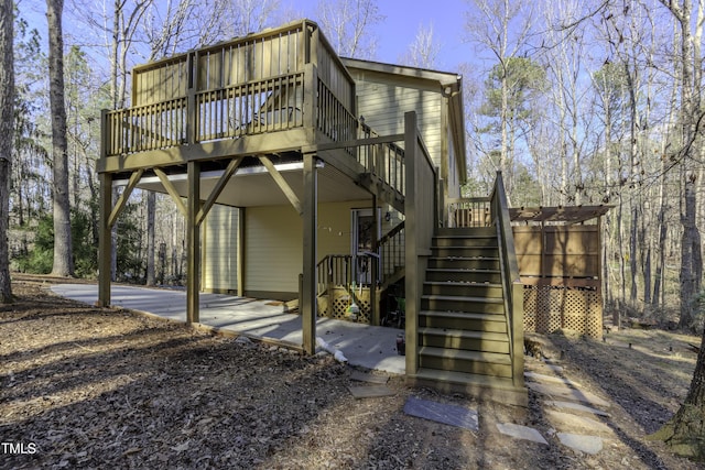 rear view of property featuring a deck and stairs