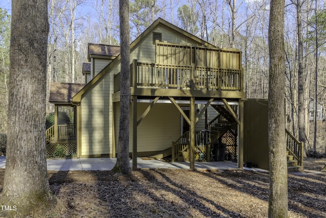 rear view of house with a deck and a shingled roof