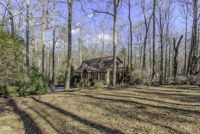 view of front of home with a view of trees and a front lawn