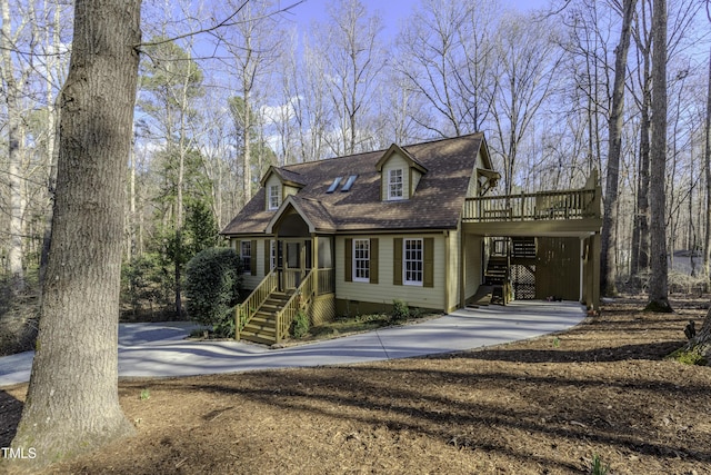 new england style home with a carport, roof with shingles, a deck, crawl space, and driveway