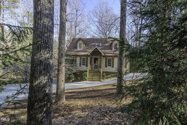 new england style home with crawl space and roof with shingles