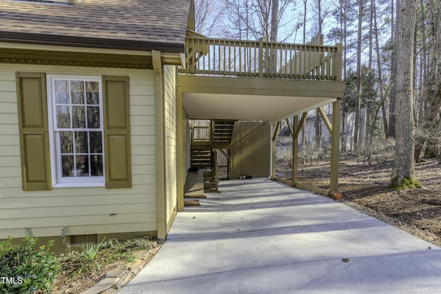 view of patio with stairway, an attached carport, a deck, and driveway