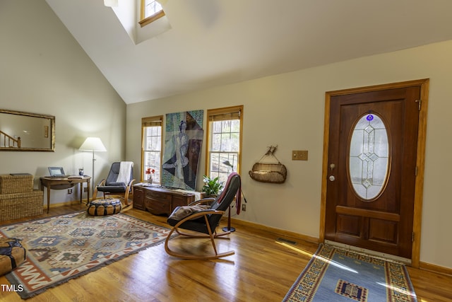 entrance foyer featuring visible vents, high vaulted ceiling, wood finished floors, stairway, and baseboards