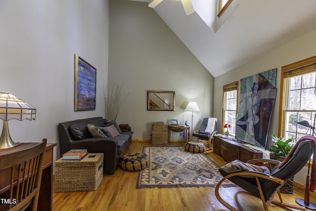 living area featuring wood finished floors and high vaulted ceiling