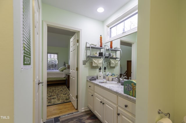 bathroom with recessed lighting, connected bathroom, vanity, and wood finished floors