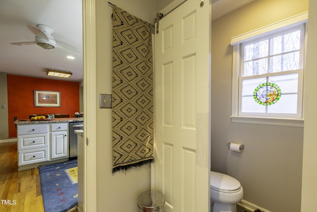 bathroom featuring plenty of natural light, toilet, a ceiling fan, and wood finished floors