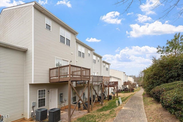 back of property featuring a residential view, a deck, and central AC unit