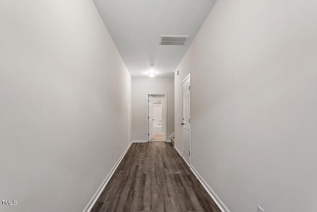 hallway with baseboards and visible vents