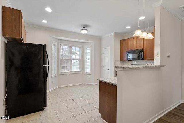 kitchen with black appliances, tasteful backsplash, brown cabinetry, and crown molding