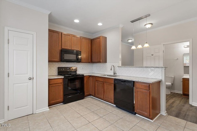 kitchen with brown cabinetry, a sink, a peninsula, and black appliances