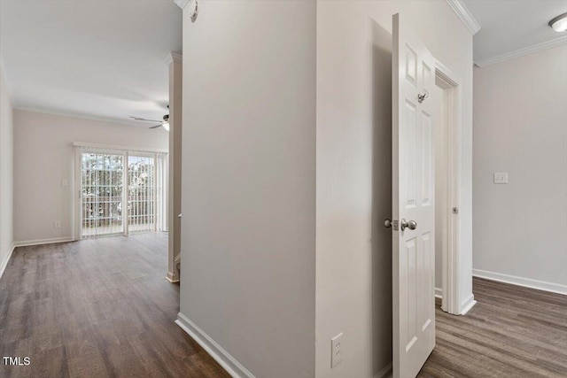 hall featuring ornamental molding, dark wood-style flooring, and baseboards