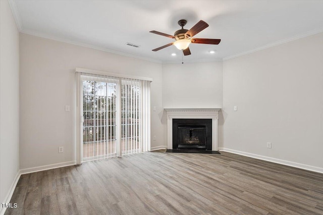 unfurnished living room with wood finished floors, a fireplace with flush hearth, visible vents, baseboards, and ornamental molding