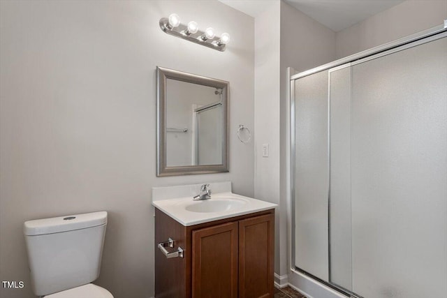 bathroom featuring toilet, a stall shower, and vanity