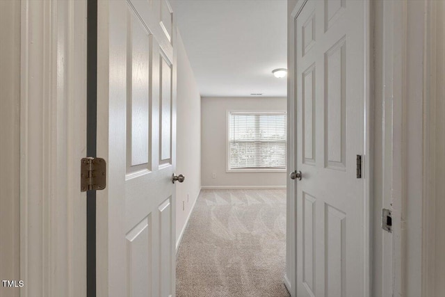 hallway with carpet floors and baseboards