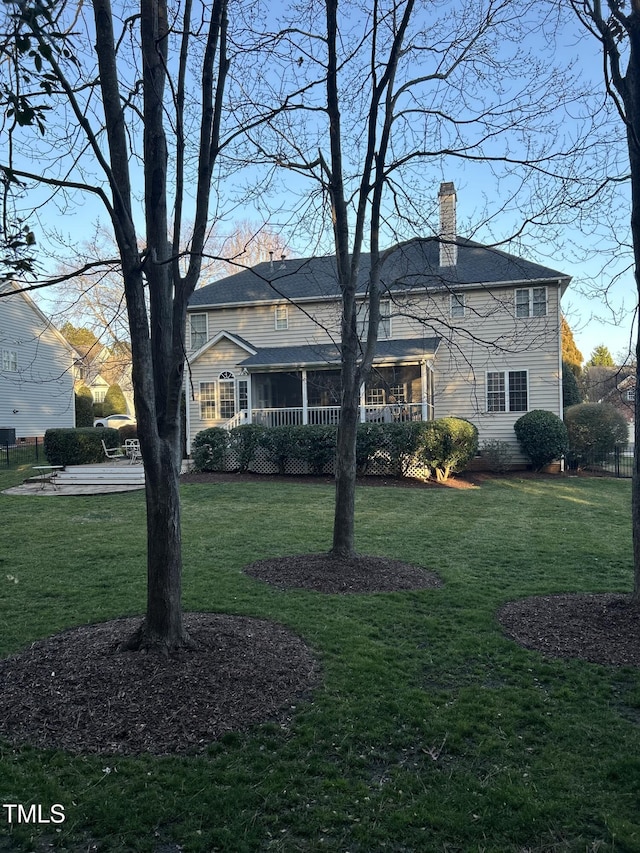 view of front of property featuring a front lawn, a chimney, and fence