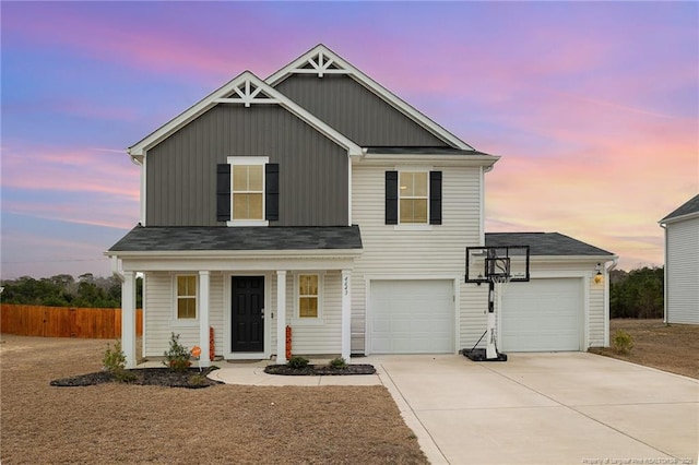 traditional-style home featuring a porch, concrete driveway, and fence