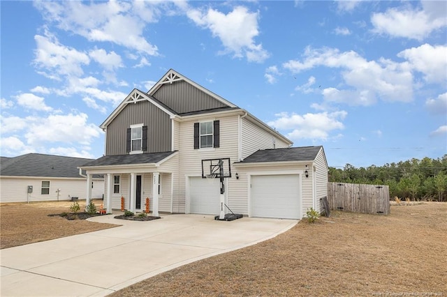 view of front of house with driveway, board and batten siding, an attached garage, and fence