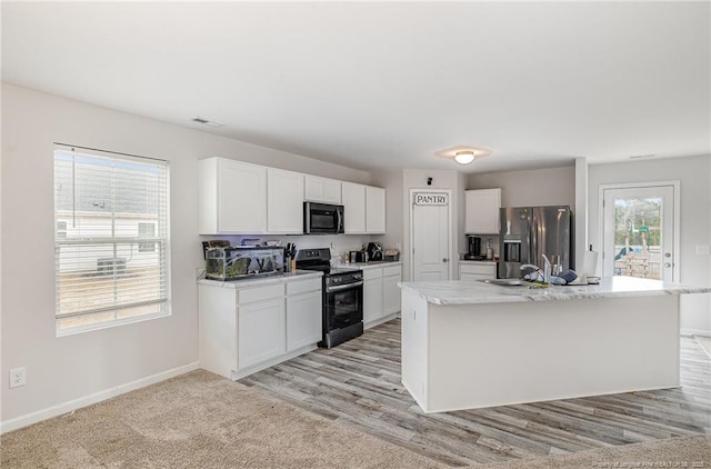 kitchen featuring baseboards, appliances with stainless steel finishes, white cabinets, and light countertops