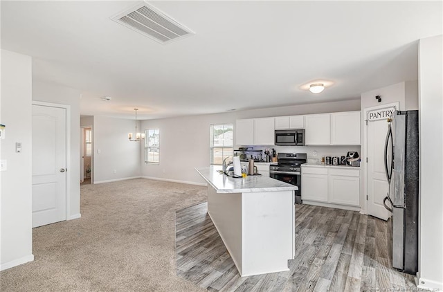 kitchen featuring white cabinetry, visible vents, stainless steel appliances, and baseboards