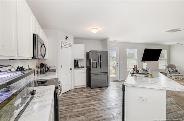 kitchen with light wood-style flooring, a sink, visible vents, open floor plan, and stainless steel fridge with ice dispenser