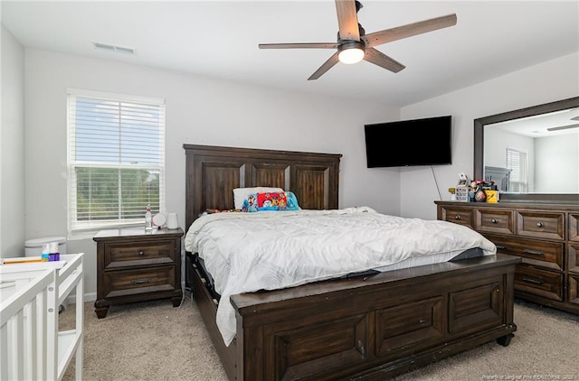 bedroom with visible vents, ceiling fan, and light carpet