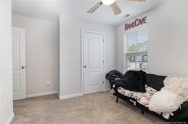 living area featuring light carpet, baseboards, visible vents, and a ceiling fan