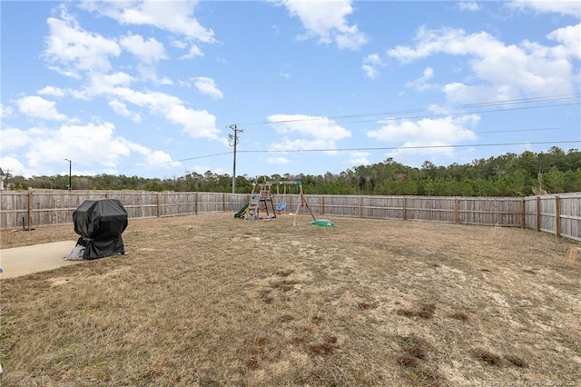 view of yard with a playground and a fenced backyard