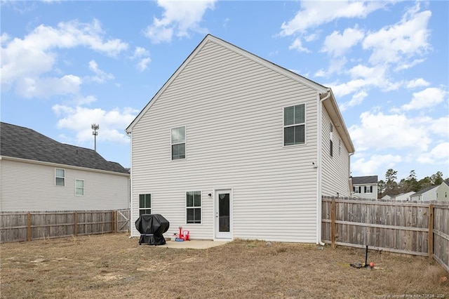 rear view of property featuring a patio and a fenced backyard