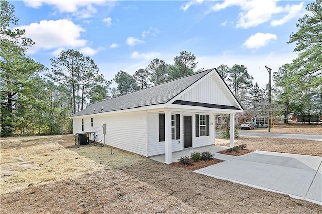 view of property exterior featuring cooling unit and roof with shingles