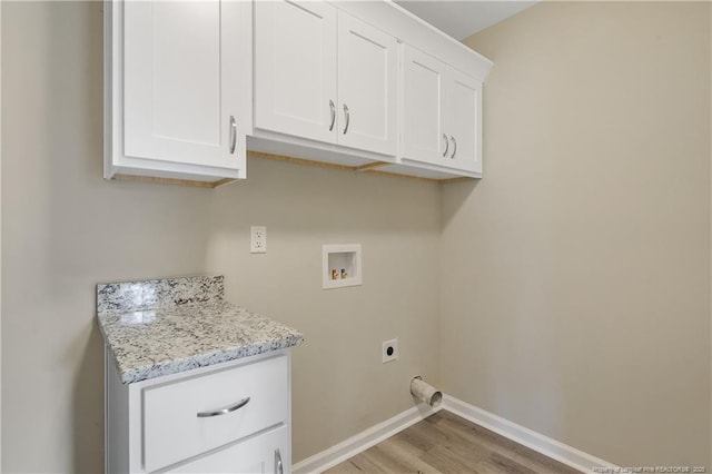 laundry room featuring hookup for a washing machine, baseboards, cabinet space, electric dryer hookup, and light wood-type flooring