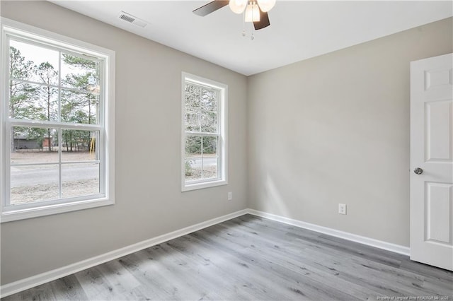 unfurnished room featuring visible vents, a ceiling fan, baseboards, and wood finished floors