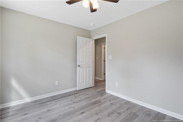 empty room featuring a ceiling fan, wood finished floors, and baseboards