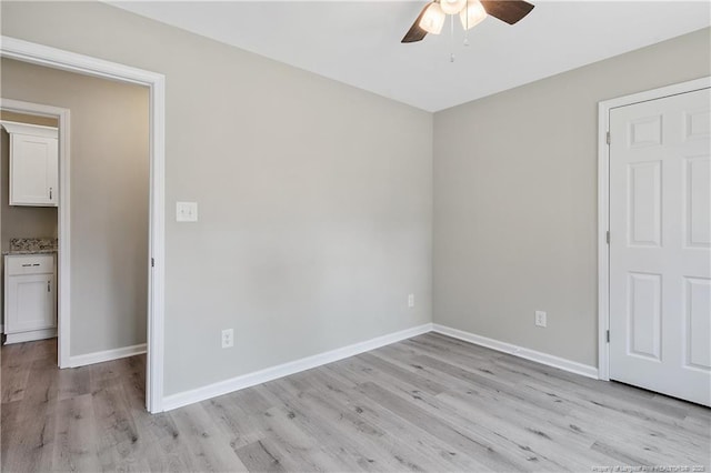 unfurnished bedroom with a ceiling fan, baseboards, and light wood-type flooring