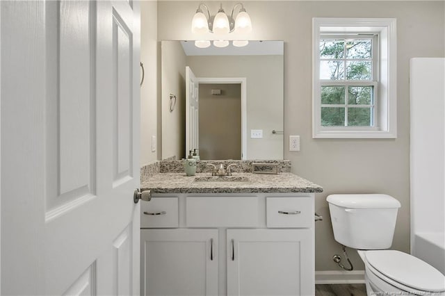 bathroom with baseboards, toilet, and vanity