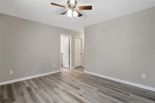 unfurnished room featuring ceiling fan, baseboards, and wood finished floors