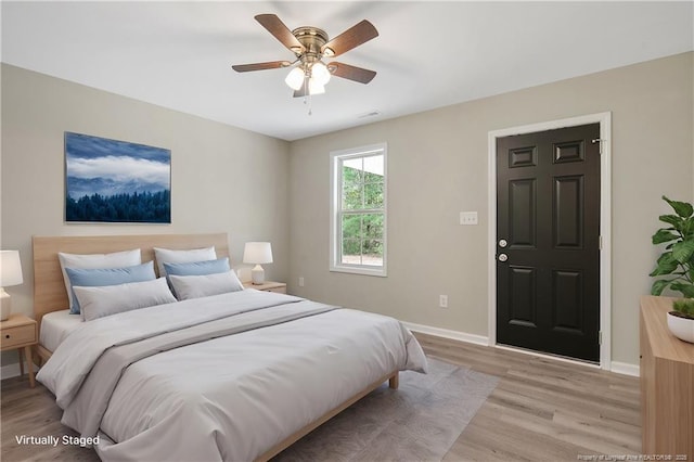 bedroom with visible vents, baseboards, light wood-style floors, and a ceiling fan