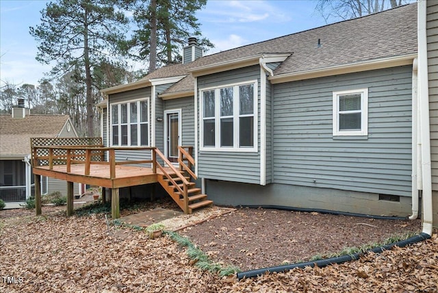 rear view of house featuring a deck, a shingled roof, crawl space, and a chimney