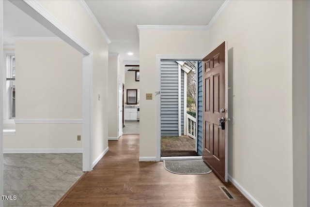 entryway featuring baseboards, wood finished floors, visible vents, and crown molding