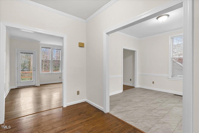 unfurnished room with crown molding, baseboards, and wood finished floors