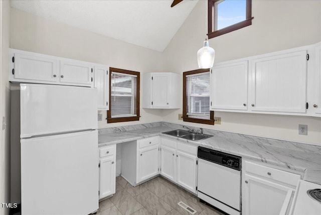 kitchen with white appliances, visible vents, white cabinets, vaulted ceiling, and a sink