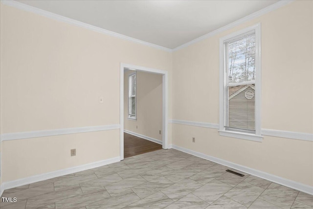 spare room with baseboards, visible vents, and crown molding