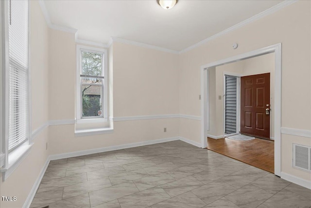 spare room featuring visible vents, crown molding, and baseboards