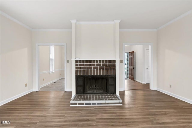 unfurnished living room with a fireplace, ornamental molding, and wood finished floors