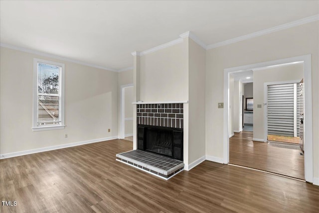 unfurnished living room featuring baseboards, a fireplace, wood finished floors, and crown molding